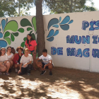 Foto dels participants del projecte ‘Lleida Street-Art’ al costat del mural que han pintat a la façana exterior de les piscines del barri de Magraners.