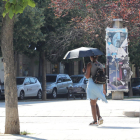 Una dona protegint-se del sol amb un paraigua ahir a la tarda a la ciutat de Lleida.