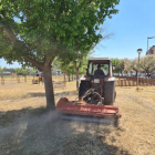 Imagen de un tractor cortando la hierba seca del Bosquet. 