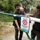 Dos Agentes Rurales colocando un cartel de prohibición del paso en el Montsec en la zona de Corçà por la activación del plan Alfa 3