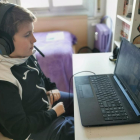 El Víctor, confinat per la Covid, segueix la classe per via telemàtica.