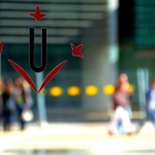 Un cristal con el logotipo de la Universitat de Lleida (UdL) y estudiantes andando al fondo