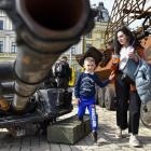 Civils ucraïnesos observen restes militars russes exposades al centre de Kíiv.