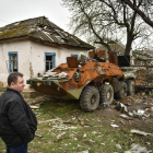 Un civil ucraïnès observa les restes calcinades d’un blindat rus a Txerníhiv.