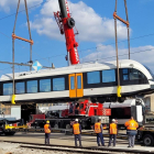 Operaris descarreguen la tercera unitat de tren de la línia Lleida-la Pobla a l'estació del Pla de Vilanoveta de Lleida