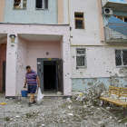 Un hombre recoge escombros en su casa en Járkov.