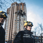 Dos bomberos ante un edificio de viviendas en el centro de Kiev en el que impactó un misil ayer.