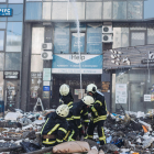 Bombers intenten apagar un foc d'un edifici civil bombardejat, en una zona residencial, a 26 de febrer de 2022, a Kíev