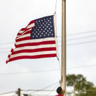 Un norteamericano baja la bandera a media asta por el tiroteo en Texas.