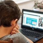 Imatge d'arxiu en què un nen utilitza un ordinador portàtil.