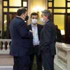 El expresidente Artur Mas y el exvicepresidente Oriol Junqueras, acompañado de un colaborador, charlan antes de la investidura del presidente de la Generalitat, Pere Aragonès, el 21 de mayo de 2021.