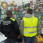 Un agente de la Guardia Civil y otro de la policía local de Balaguer, dentro de la tienda donde se vendían accesorios de telefonía móvil falsificados