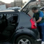 Un agente de la Guardia Civil registra el vehículo de uno de los detenidos en la operación policial. 