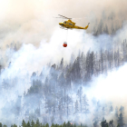 Un helicòpter descarrega aigua sobre l’incendi forestal a Tenerife.
