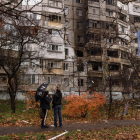 Dos ciutadans ucraïnesos, davant d’un edifici danyat per bombes russes a Kherson.