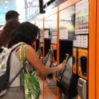 Una usuària de Rodalies Renfe comprant un bitllet de tren a les taquilles de l'Estació de Sants de Barcelona.