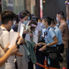 Policías chinos identifican a manifestantes en una vigilia por las víctimas de la política cero-Covid.