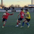 Marcos López golpea el balón ante Guido y un jugador rival.