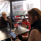 Una dona consulta el missatge de Protecció Civil a la terrassa d’un bar a la Pobla de Segur.