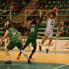 Michael Carrera intenta llançar des d'una posició molt forçada davant de l'intent de tap de Belemene.