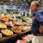 Un hombre observa los precios de los tomates en un supermercado. 