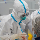 Un trabajador médico habla con un paciente en un hospital improvisado por la pandemia de COVID-19 en China.