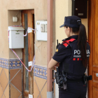 Una agente de los Mossos delante de la casa del presunto asesino, que se encuentra precintado