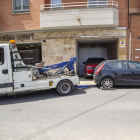 Una grua retira un vehicle estacionat en un gual a Lleida.