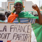 Un manifestant amb un cartell on es llegeix “França se n’ha d’anar”.