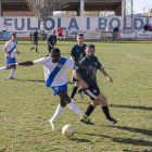 Un jugador local conduce el balón, ante la presión de un oponente del Vallfogona.