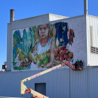 Lily Brick pintando el mural sobre la fruticultura del Pla d’Urgell en la sede de Nufri, en Mollerussa. 