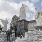 Voluntarios cubren con sacos terreros los monumentos de Kiev para protegerlos de los ataques.