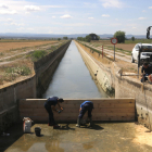 Operarios del Canal d'Urgell preparan las vallas para reservar el agua para los municipios