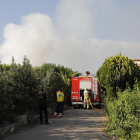 Imagen de la columna de humo (izquierda) y de dos bomberos trabajando en la extinción del fuego (derecha). 