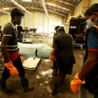 Varias personas buscando a conocidos entre los fallecidos, en una morgue.