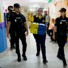 Una funcionària de Correus amb vots escortada per la Policia.