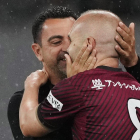 Xavi i Iniesta s’abracen durant el partit d’ahir.