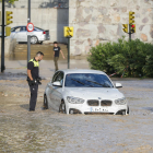 AgAgentes de la Policia Local observen un cotxe arrossegat per la tempesta caiguda aquest dijous en Zaragoza.entes de la Policia Local observen un cotxe arrossegat per la tempesta caiguda aquest dijous a Saragossa.