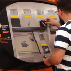 Un noi utilitzant una màquina d'autovenda de Rodalies el primer dia en vigor dels abonaments gratuïts.