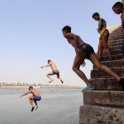 Varios niños se lanzan al agua del Nilo para refrescarse, en Qanater, en las afueras de El Cairo