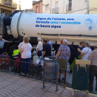 Veïns de Bovera feien cua divendres per omplir les garrafes davant d’una cisterna amb un eslògan a favor de beure aigua de l’aixeta.