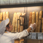 Imagen de archivo de una trabajadora de una panadería de Lleida cogiendo una barra. 