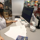 Una farmacèutica de Lleida ciutat intenta, sense èxit, dispensar un medicament.