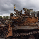 Soldats ucraïnesos sobre un tanc rus destruït exhibit al centre de Kíiv.