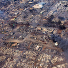 Una fotografia aèria mostra edificis destruïts i arbres cremats a causa dels incendis forestals.