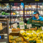 Una trabajadora reponiendo fruta en un supermercado.