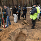 Investigadores documentan los hallazgos en la fosa común descubierta en la ciudad de Izium.