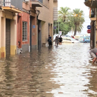 Vecinos achican agua de sus casas en la calle Sant Joan de Mataró tras la tromba del viernes.