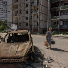 Una mujer pasa este lunes junto a un coche quemado en Chernígov, en el norte de Ucrania.