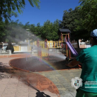 Un empleado de la brigada limpiando un parque infantil.